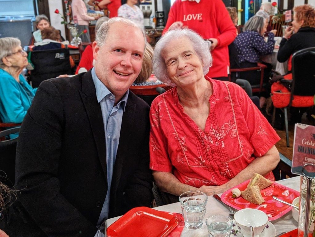 Image of Christopher and Sharon Holcroft sitting together side-by-side smiling.